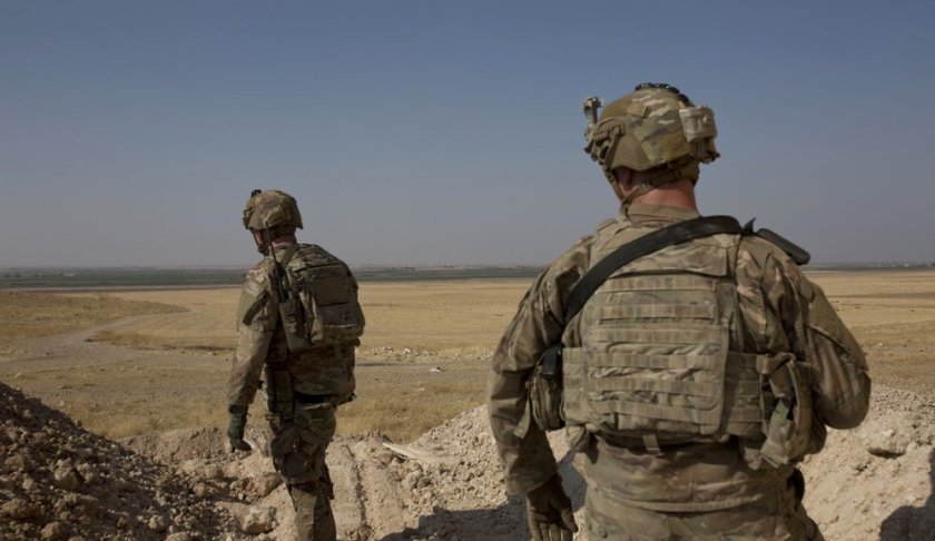 FILE - In this Sept. 6, 2019 file photo, U.S. soldiers survey the the safe zone between Syria and the Turkish border near Tal Abyad, Syria, on a joint patrol with the Tax Abyad Military Council, affiliated with the U.S.-backed Syrian Democratic Forces. Defense Secretary Mark Esper says that under the current plan all U.S. troops leaving Syria will go to western Iraq, and that the military will continue to conduct operations against the Islamic State group to prevent a resurgence in that country. (AP Photo/Maya Alleruzzo, File)