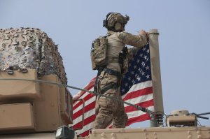 American soldier mount the U.S. flag on a vehicle near the town of Tel Tamr, north Syria, Sunday, Oct. 20, 2019. (AP Photo/Baderkhan Ahmad)