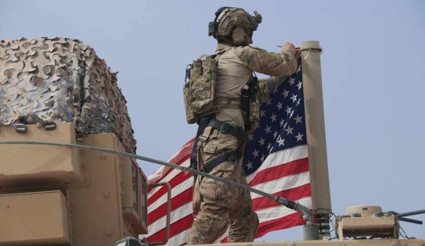American soldier mount the U.S. flag on a vehicle near the town of Tel Tamr, north Syria, Sunday, Oct. 20, 2019. (AP Photo/Baderkhan Ahmad)