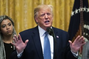 President Donald Trump speaks at the Young Black Leadership Summit 2019 in the East Room of the White House in Washington, Friday, Oct. 4, 2019. Kearyn Bolin, back left, of Texas State University listens. (AP Photo/Manuel Balce Ceneta)