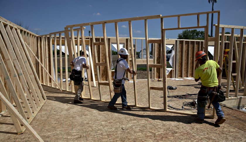 Workers carry a wall frame for a home under construction at a K. Hovnanian Homes development in Plano, Illinois, U.S., on Wednesday, May 15, 2019. (Credit: CNN)