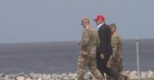 Trump walks near the boarder with military personnel. (Credit: CBS News)