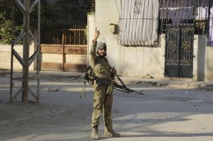 In this Saturday, Oct. 12, 2019 photo, Turkey-backed Syrian fighter stand in Ras al-Yan, Syria.Turkey's military says it has captured a key Syrian border town Ras al-Ayn under heavy bombardment in its most significant gain as its offensive against Kurdish fighters presses into its fourth day. (AP Photo)