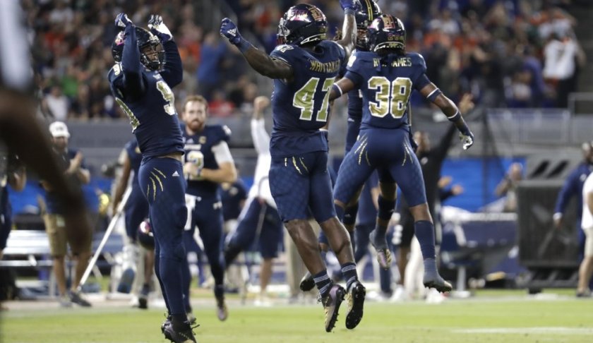 FIU defensive lineman Noah Curtis, left, and linebacker Chris Whittaker (47) celebrate after their team stopped Miami on fourth down during the first half of an NCAA college football game, Saturday, Nov. 23, 2019, in Miami. (AP Photo/Lynne Sladky)