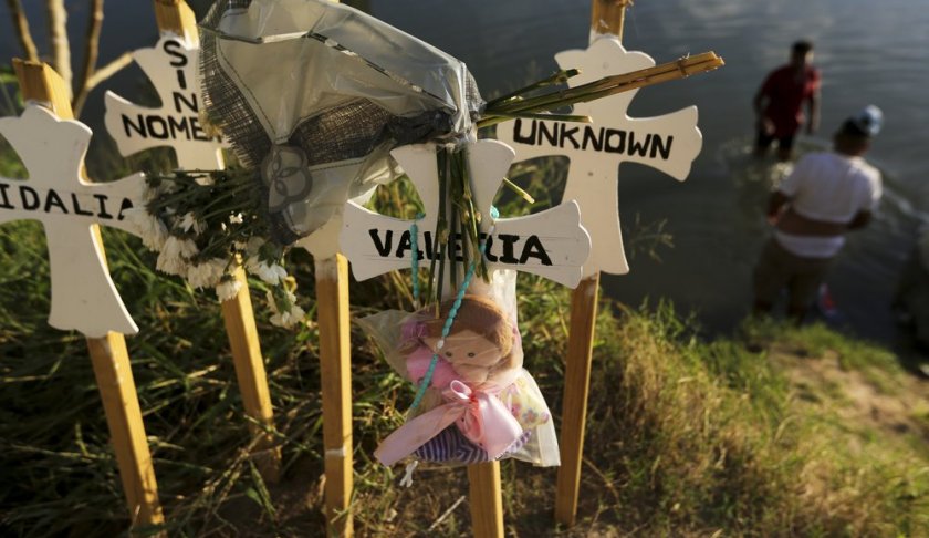 In this Oct. 11, 2019 photo, crosses covered with the names of people who have drowned trying to cross the river stand on the bank of the Rio Grande in Matamoros, Mexico. Migrants who make it this far, tell stories of being captured by armed bandits who demand a ransom: They can pay for illegal passage to the border, or merely for their freedom, but either way they must pay. (AP Photo/Fernando Llano)