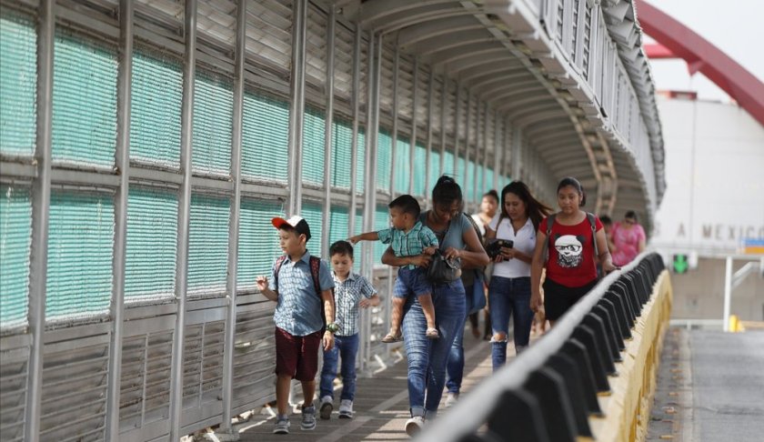 FILE - In this June 28, 2019 file photo, local residents with visas walk across the Puerta Mexico international bridge to enter the U.S., in Matamoros, Tamaulipas state, Mexico. A federal judge in Portland, Ore., on Saturday, Nov. 2, 2019, put on hold a Trump administration rule requiring immigrants prove they will have health insurance or can pay for medical care before they can get visas. U.S. District Judge Michael Simon granted a preliminary injunction that prevents the rule from going into effect Sunday. (AP Photo/Rebecca Blackwell, File)