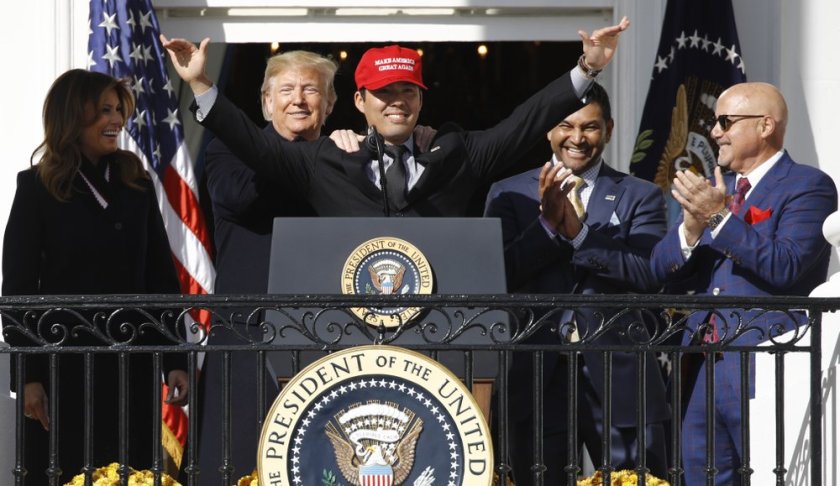 President Donald Trump stands with Washington Nationals catcher Kurt Suzuki, during an event to honor the 2019 World Series champion Washington Nationals on the balcony of the White House, Monday, Nov. 4, 2019, in Washington, as First Lady Melania Trump, left, and Washington Nationals coach Dave Martinez, second from right and general manager Mike Rizzo, far right, look on. Suzuki is wearing a Make America Great Again hat. (AP Photo/Patrick Semansky)
