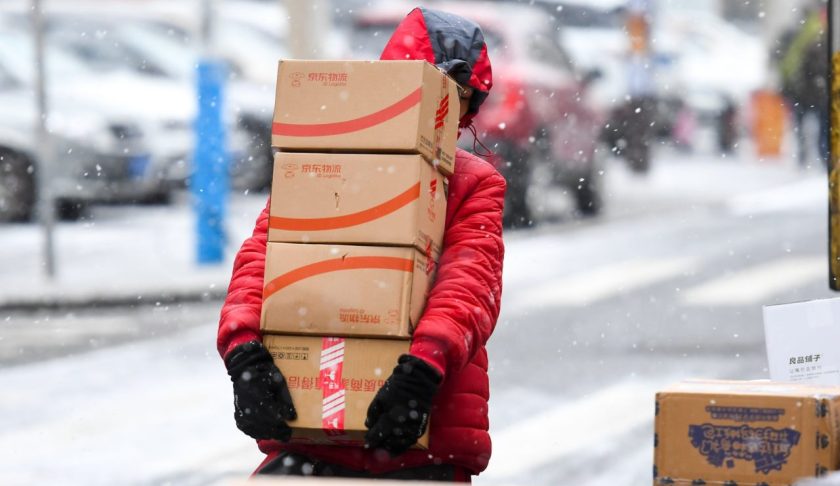 A JD.com employee carries parcels in snow on November 13, 2019 in Changchun, Jilin Province of China. (Credit: VCG via Getty Images)
