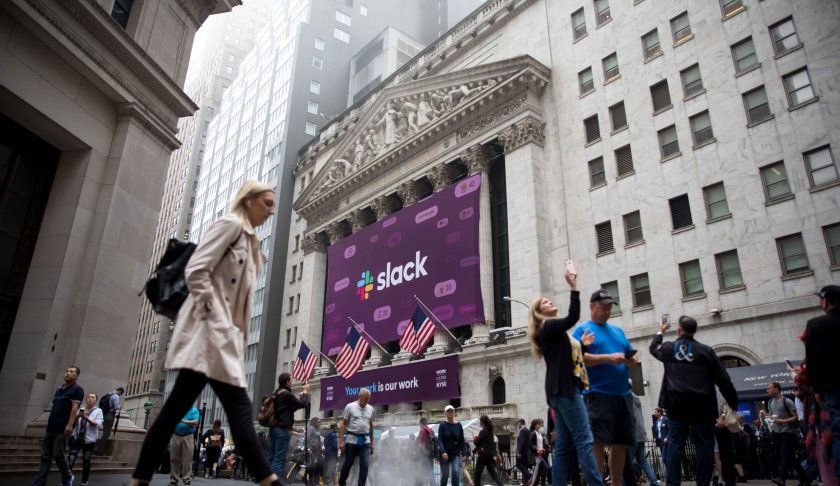 Pedestrians pass in front of a Slack Technologies Inc. signage displayed outside of the New York Stock Exchange (NYSE) during the company's initial public offering (IPO) in New York, U.S., on Thursday, June 20, 2019. (Credit: Michael Nagle/Bloomberg/Getty)