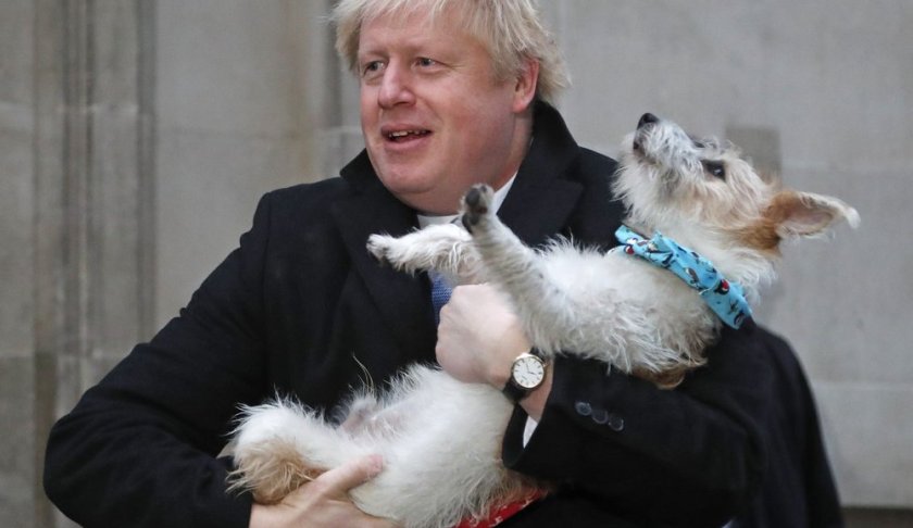 Britain's Prime Minister and Conservative Party leader Boris Johnson holds his dog Dilyn as he leaves after voting in the general election at Methodist Central Hall, Westminster, London, Thursday, Dec. 12, 2019. The general election in Britain on Thursday will bring a new Parliament to power and may lead to a change at the top if Prime Minister Boris Johnson's Conservative Party doesn't fare well with voters. Johnson called the early election in hopes of gaining lawmakers to support his Brexit policy. (AP Photo/Frank Augstein)