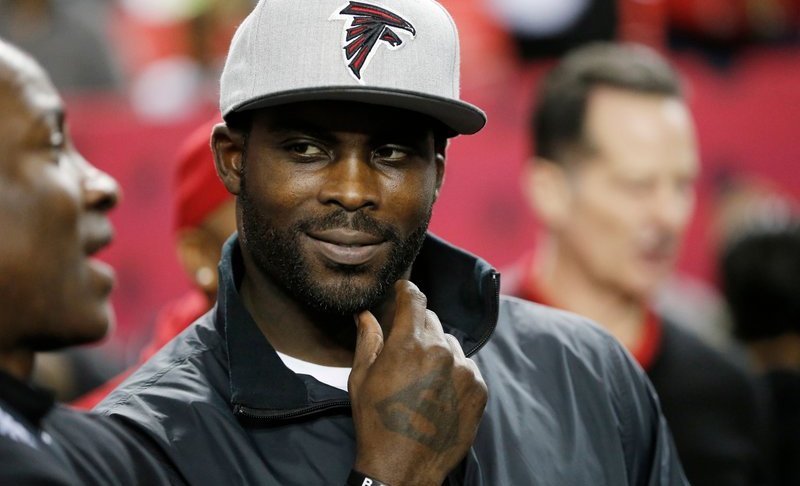 FILE - In this Jan. 1, 2017, file photo, former Atlanta Falcons quarterback Michael Vick stands on the sidelines before an NFL football game between the Falcons and the New Orleans Saints in Atlanta. (AP Photo/John Bazemore, File)