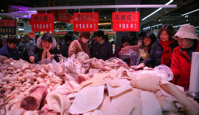 This photo taken on December 19, 2019 shows people trying to buy meat at a newly-opened supermarket in Binzhou, in China's eastern Shandong Province. - The supermarket offered 3 tonnes of pork at discounted prices as a promotion. Pork prices in China have doubled this year following an outbreak of African swine fever. (Photo by STR / AFP) / China OUT (Photo by STR/AFP via Getty Images)