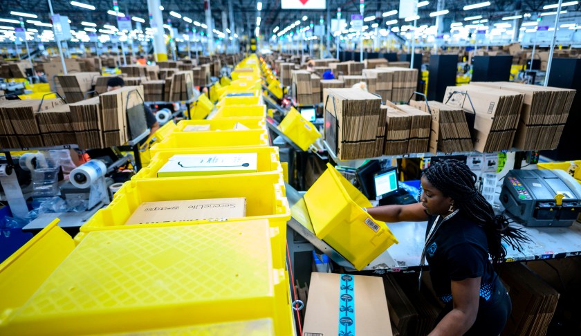 A woman works at a packing station at the 855,000-square-foot Amazon fulfillment center in Staten Island, one of the five boroughs of New York City, on February 5, 2019. - Inside a huge warehouse on Staten Island thousands of robots are busy distributing thousands of items sold by the giant of online sales, Amazon. (Photo by Johannes EISELE / AFP) (Photo credit should read JOHANNES EISELE/AFP via Getty Images)