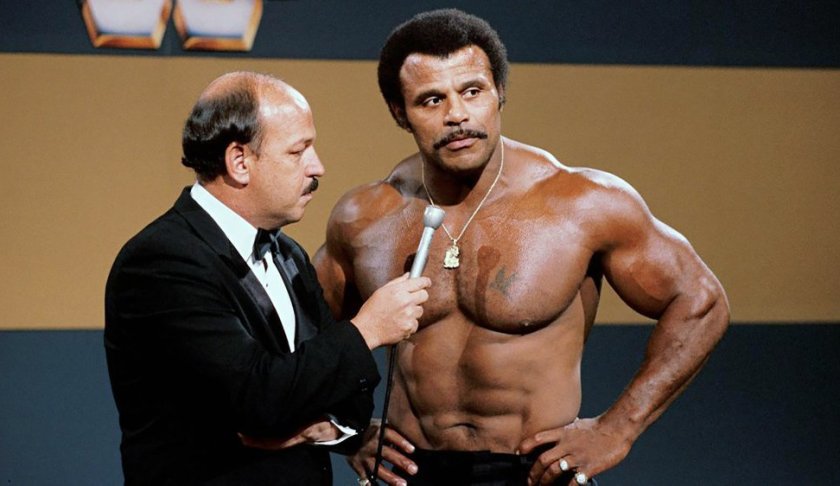 In this undated photo provided by WWE, Inc., "Mean" Gene Okerlund interviews Rocky "Soul Man" Johnson. Johnson, a WWE Hall of Fame wrestler who became better known as the father of actor Dwayne “The Rock” Johnson, died Wednesday, Jan. 15, 2020. He was 75. (WWE, Inc. via AP)