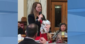 In this March 2017, photo, provided by Rep. Kimberly Dudik, Dudik speaks on the floor of the legislature holding her newborn son Marcutio in Helena, Mont. As experts predict another banner year of women running for office, hurdles remain particularly for those like Dudik who have young children. Only six states have laws specifically allowing the use of campaign funds for child care. In most states, including Montana, the law is silent on the issue and up to interpretation by state agencies or boards. (Rep. Nate McConnell/Rep. Kimberly Dudik via AP)