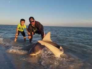 Steele with his dad, C.J., after catching a shark twice his size. (Credit: Floyd family)