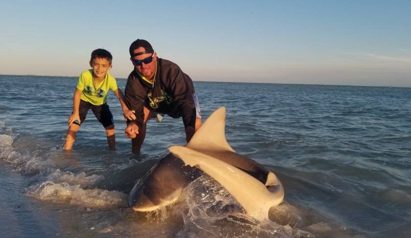 Steele with his dad, C.J., after catching a shark twice his size. (Credit: Floyd family)