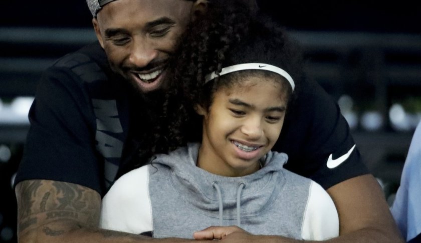 FILE - In this July 26, 2018, file photo former Los Angeles Laker Kobe Bryant and his daughter Gianna watch during the U.S. national championships swimming meet in Irvine, Calif. Federal investigators say wreckage from the helicopter that crashed last month and killed Bryant, his daughter and seven others did not show any outward evidence of engine failure, the National Transportation Safety Board said Friday, Feb. 7, 2020. (AP Photo/Chris Carlson,File)