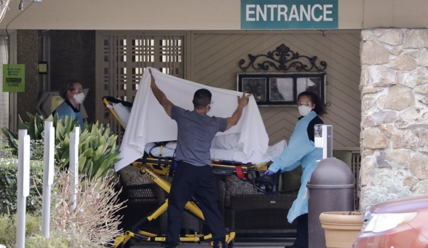 A person is taken by stretcher to a waiting ambulance from a nursing facility where more than 50 people are sick and being tested for the COVID-19 virus, Saturday, Feb. 29, 2020, in Kirkland, Wash. (AP Photo/Elaine Thompson)