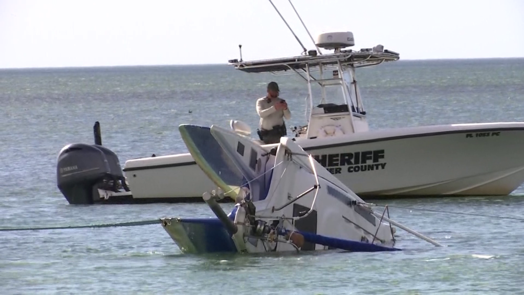 Capsized boat gets towed to shore near Wiggins Pass