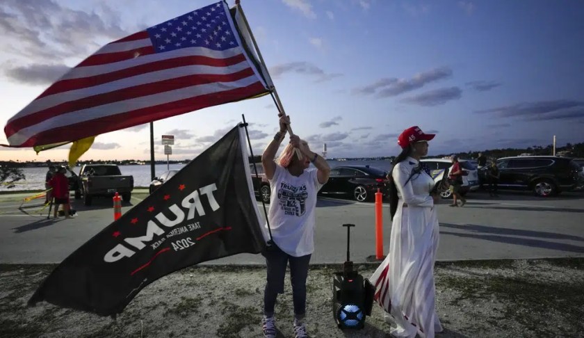 Trang Le of Orlando, right, and Maria Korynsel of North Palm Beach show their support for former President Donald Trump after the news broke that Trump has been indicted by a Manhattan grand jury, Thursday, March 30, 2023, near Trump's Mar-a-Lago estate in Palm Beach, Fla. (AP Photo/Rebecca Blackwell)