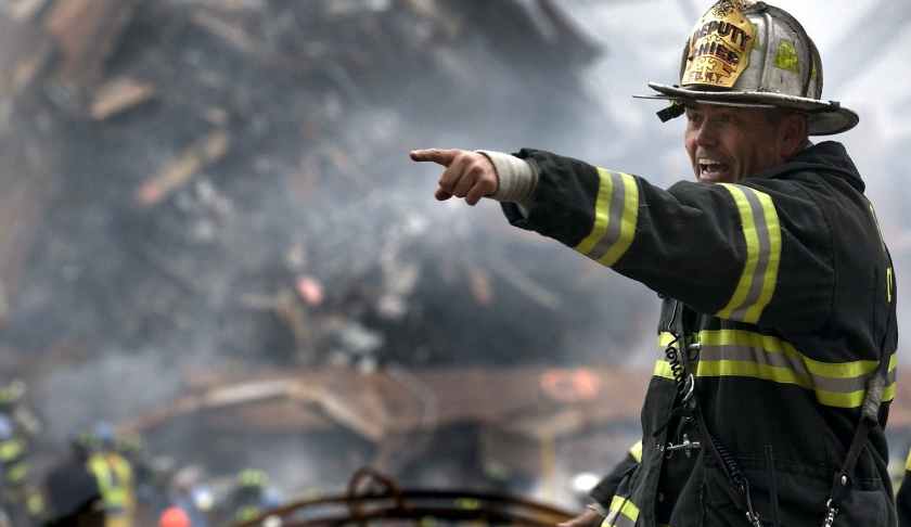 fire fighter wearing black and yellow uniform pointing for something