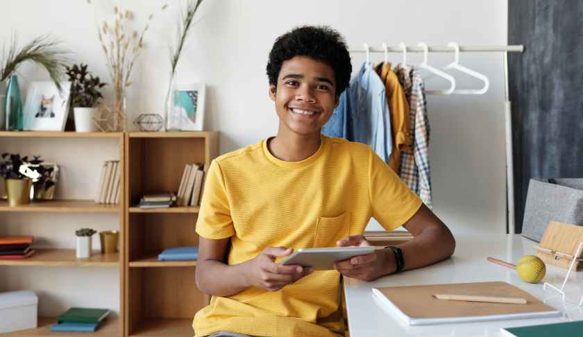 boy in yellow crew neck t shirt sitting on chair