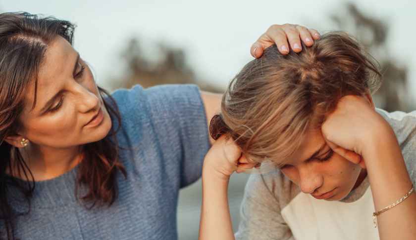 woman in blue shirt talking to a young man in white shirt