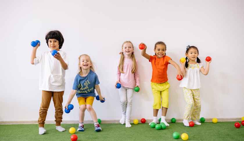 little girls and boys having fun playing with colorful balls