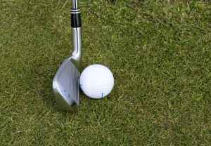 silver wedge golf club beside ball