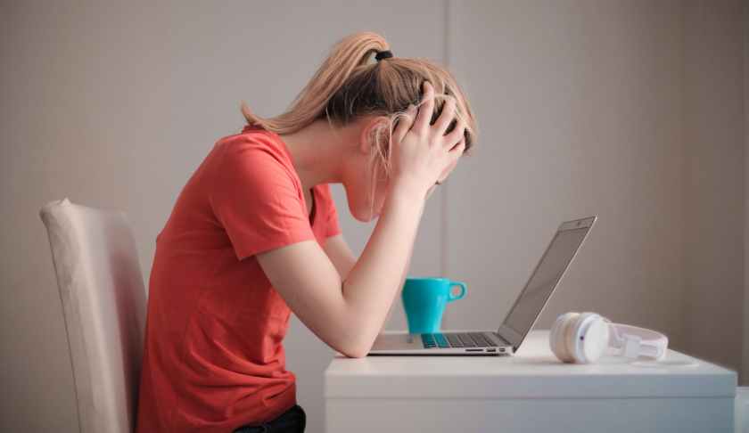 woman in red t shirt looking at her laptop