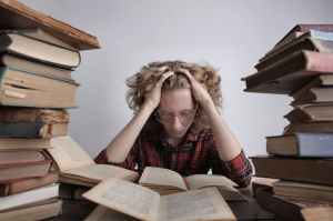 smart teenager reading book at table