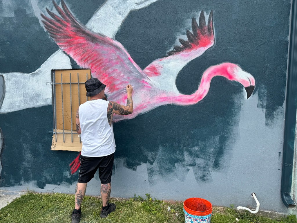An artist works on one of the murals in in downtown Fort Myers. CREDIT: WINK News