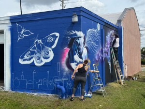 An artist at work on a mural in downtown Fort Myers. CREDIT: WINK News