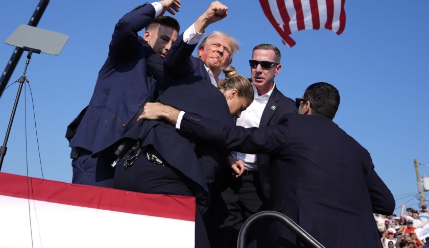 Trump raises fist after being shot at rally. AP Photo by Evan Vucci