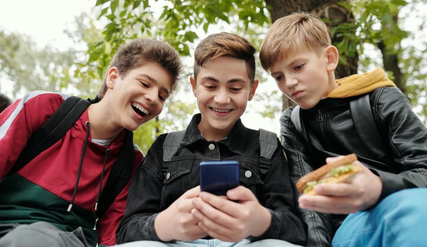 a three boys looking the smartphone