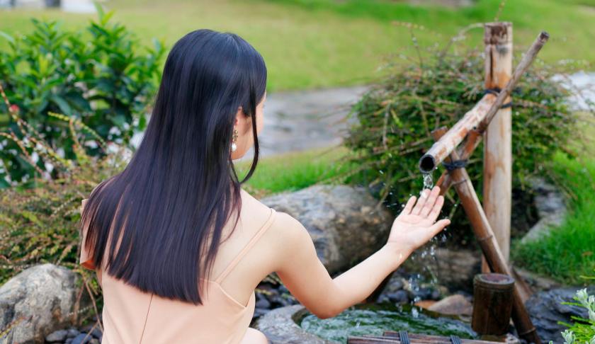 woman crouching by well