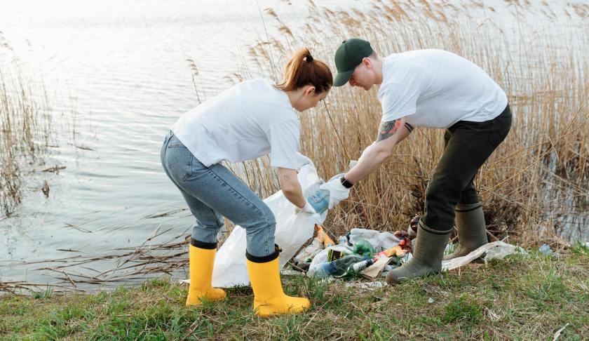 a man and a woman picking up garbage